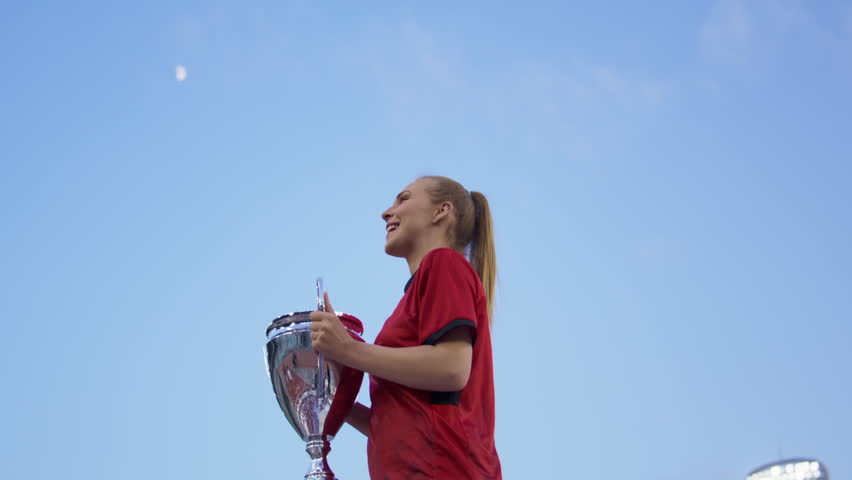 Portrait of Caucasian female soccer football player celebrating victory in the championship, lifting the trophy above her head in a huge stadium. Super slow motion, shot on RED cinema camera Royalty-Free Stock Footage #1104974885