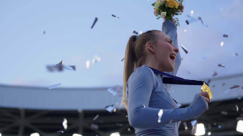 Young Female Athlete Celebrates a Win on a podium, receives a gold medal. Super slow motion, shot on RED cinema camera Royalty-Free Stock Footage #1104974887