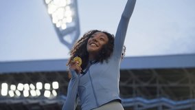 Portrait of Caucasian female soccer football player celebrating victory in the championship, lifting the trophy above her head in a huge stadium. Super slow motion, shot on RED cinema camera - Powered by Shutterstock - Get 15% off with code: PIKWIZARD15