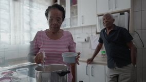 Senior African American Couple Enjoying Meal Preparation in Kitchen - Powered by Shutterstock - Get 15% off with code: PIKWIZARD15