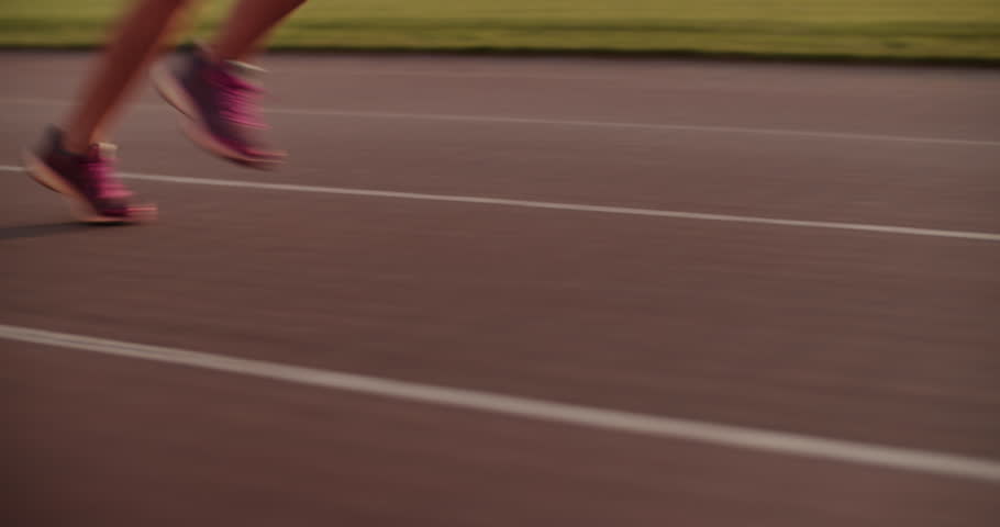 Crop female sprinter running fast on track during training