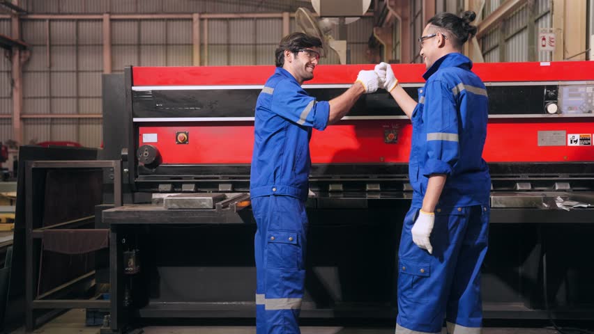 Two Industrial worker measure steel process together by Rolling Machine in steel processing plant. Expert technician men checking Metal Piece Production made by heavy steel machine in Factory