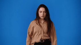 4k video of a woman thinking about something over blue background.