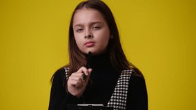 4k video of girl with thoughtful facial expression on yellow background.