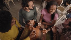 Group of multirracial young people toasting with a pint of beer and celebrating happy hours in a bar indoors. Friends drink alcohol together having fun and smiling. Cheers of gathering latin students - Powered by Shutterstock - Get 15% off with code: PIKWIZARD15