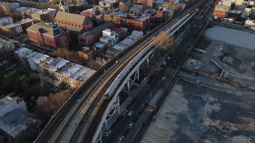 Aerial view of a subway passing through Brooklyn, New York at sunset Royalty-Free Stock Footage #1104989433