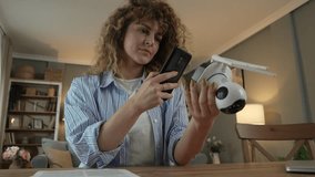 One adult caucasian woman adjust and prepare home surveillance  security camera read instructions and use smartphone to  scan activation code slow motion - Powered by Shutterstock - Get 15% off with code: PIKWIZARD15