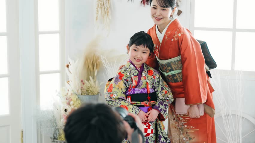 Mother and daughter in Japanese kimono. Commemorative photo in Japanese clothes. Photo studio. Royalty-Free Stock Footage #1104996689