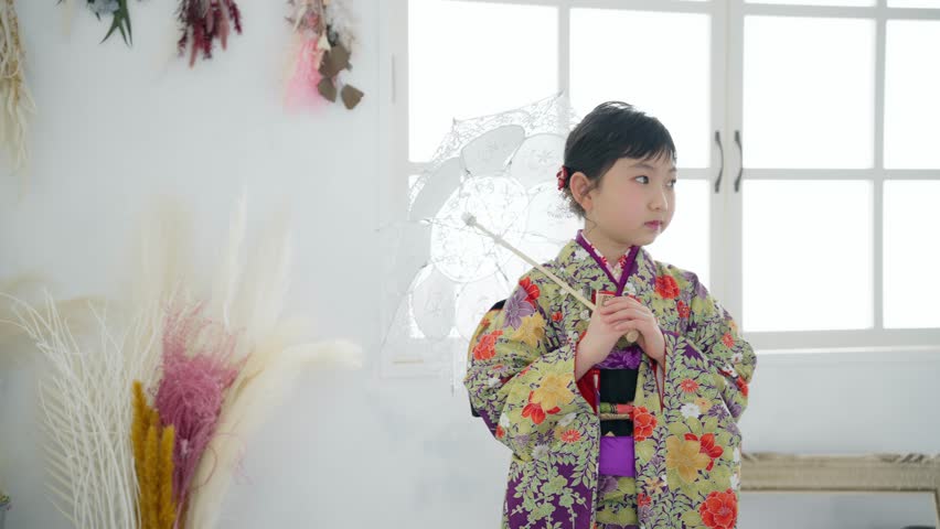 Asian little girl in Japanese kimono. Commemorative photo in Japanese clothes. Photo studio. Royalty-Free Stock Footage #1104996695