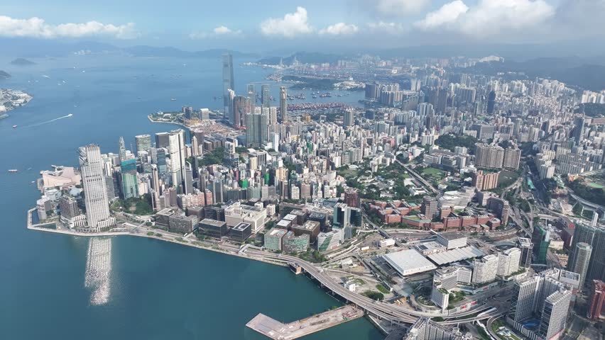 West Kowloon Cultural District, A grass field Waterfront Promenade with the cityscape of high rise buildings near Central, Victoria Harbour, Hong Kong in the background, Aerial view Royalty-Free Stock Footage #1104997875