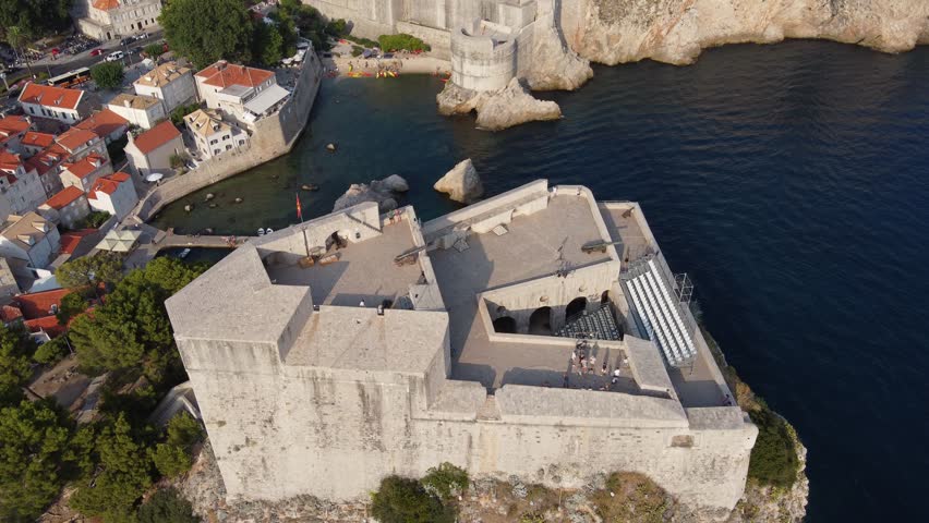 Tourists taking a guided Tour on Fort Lovrijenac against city walls of old town - King