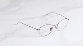 Woman Takes Eyeglasses On The Table With Marble Top Before Leaving. - close up