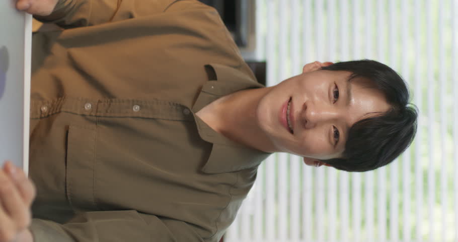 Vertical Screen: Portrait of a Handsome South Korean Male Working on a Computer Behind a Desk in a Stylish Creative Agency. Young Happy Man Closes His Laptop, Posing, Looking at Camera and Smiling