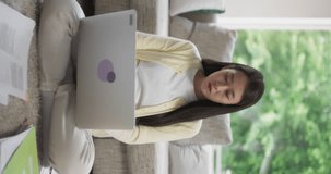Vertical Screen: South Korean Female Focused on Virtual Work from Home, Using Laptop Computer for Productive Task Management, Creating Detailed Reports for Management and International Team