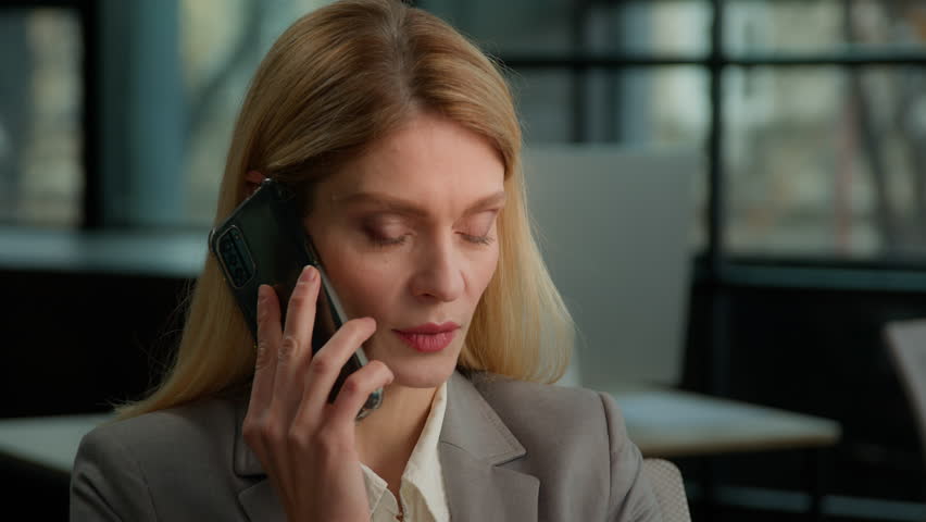 Smiling adult Caucasian 40s business woman professional lady middle-aged businesswoman talking on phone using computer sit at office desk, happy female executive make mobile call talk working online Royalty-Free Stock Footage #1105014195