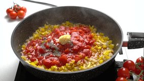 The cook puts the garlic in the Pan with Chopped Bell Peppers, Tomatoes and Onions. Recipe and cooking process for Shakshuka and Menemen. Step by step. Fourteenth video