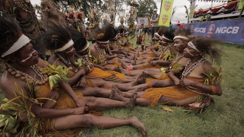 Goroka, Papua New Guinea - September 15, 2018: Goroka Show is a well-known tribal gathering and cultural event. Members of the tribe sit on the floor, sing and dance traditional songs.