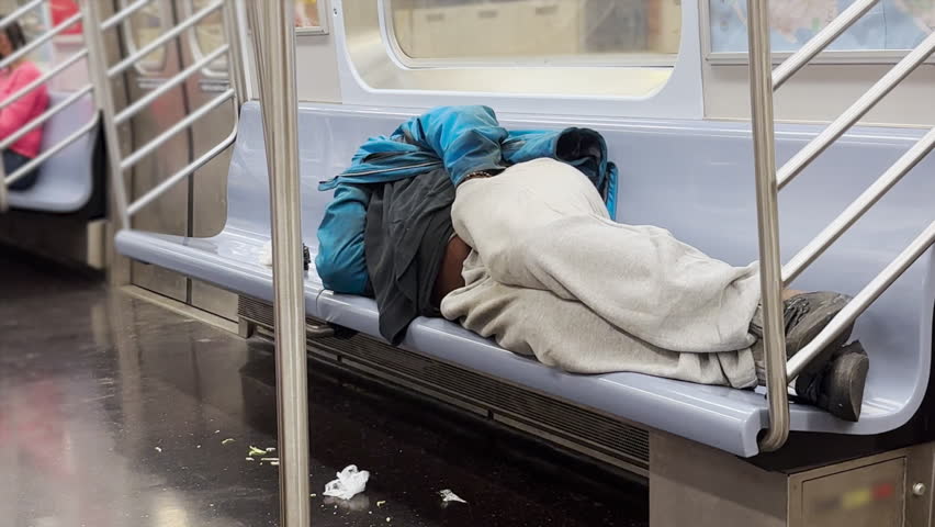 A homeless man sleeps in a Manhattan subway car.  	 Royalty-Free Stock Footage #1105019101