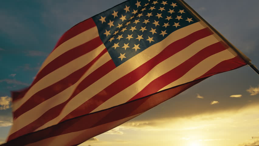 American flag waving at sunset.