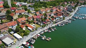 Panoramic aerial 4K video from drone to Mikolajki townscape - capital of Masurian region on the shore of the holiday resort beautiful summer afternoon. Mikolajki ,Mikołajki, Poland, Europe.