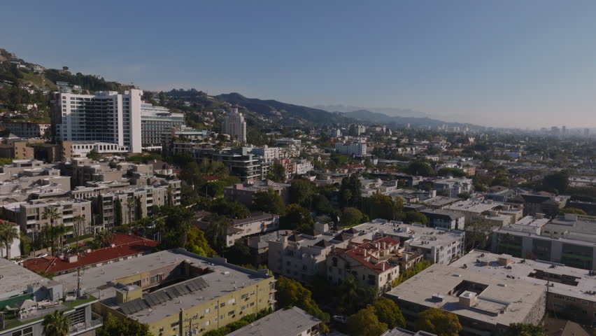 Aerial footage of luxury hotels in West Hollywood urban borough. Hills and clear blue sky. Los Angeles, California, USA