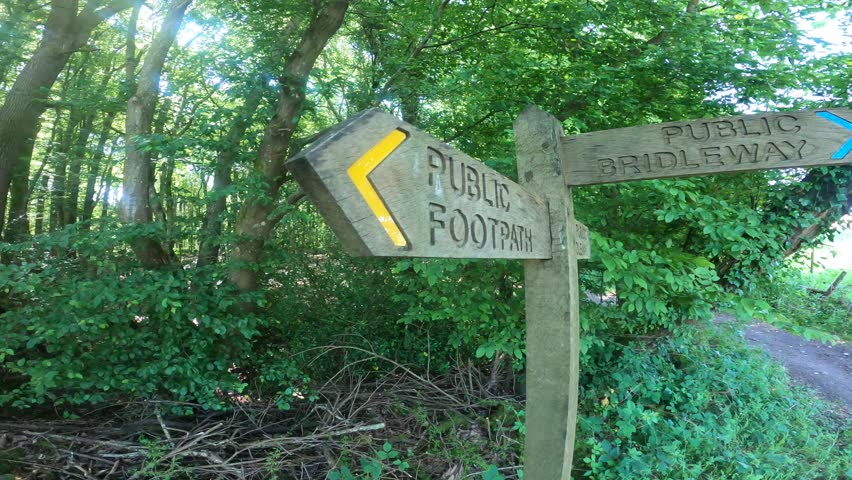 Close up footage of wooden arrow sign for public footpath