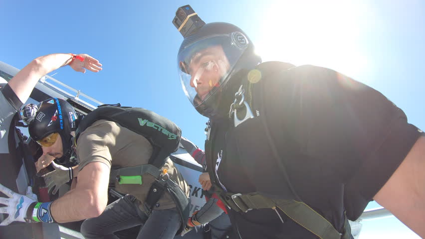 Group of skydivers jump from plane in formation