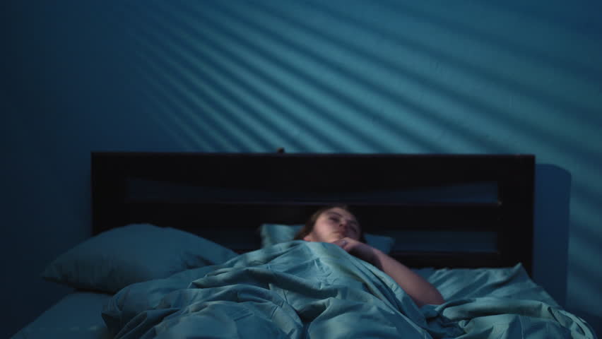 Insomnia and nightmare concept. Shocked scared woman waking up from a nightmare in her bed at night Royalty-Free Stock Footage #1105030149