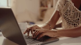 Hands of black girl typing on laptop and making notes at desk in sunlit room, working or studying online from home. Close-up shot - Powered by Shutterstock - Get 15% off with code: PIKWIZARD15