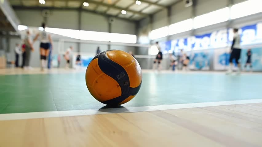 A volleyball in the background of a volleyball training session.