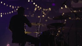 Professional drummer plays drum kit at concert. Shooting from back. Slow motion