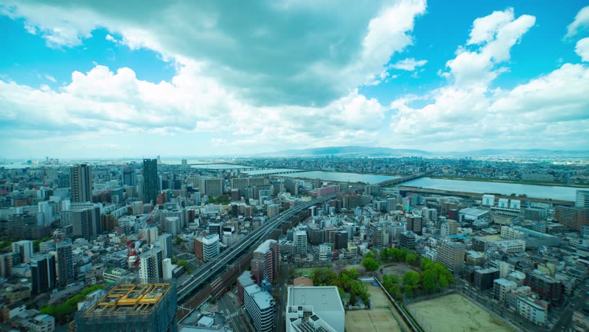 A timelapse of panorama cityscape near Yodo river in Osaka wide shot zoom Royalty-Free Stock Footage #1105039917