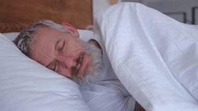 The attractive middle age man wakes up in bed. slow motion - Powered by Shutterstock - Get 15% off with code: PIKWIZARD15