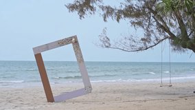 white photo frame with sand, sea and tree background, for advertising copy space of video, on a summer beach scene background.