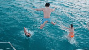 Group of diverse people having fun jumping in the sea water from the yacht during summer. Friends in swimming costume hopping at boat ladder of yacht while yachting in sunny day. Friendship concept - Powered by Shutterstock - Get 15% off with code: PIKWIZARD15