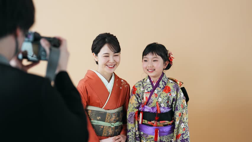 Mother and daughter in Japanese kimono. Commemorative photo in Japanese clothes. Photo studio. Royalty-Free Stock Footage #1105044559