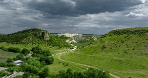 aerial hyperlapse over countryside road towards limestone quarry in fetesti with fast moving clouds