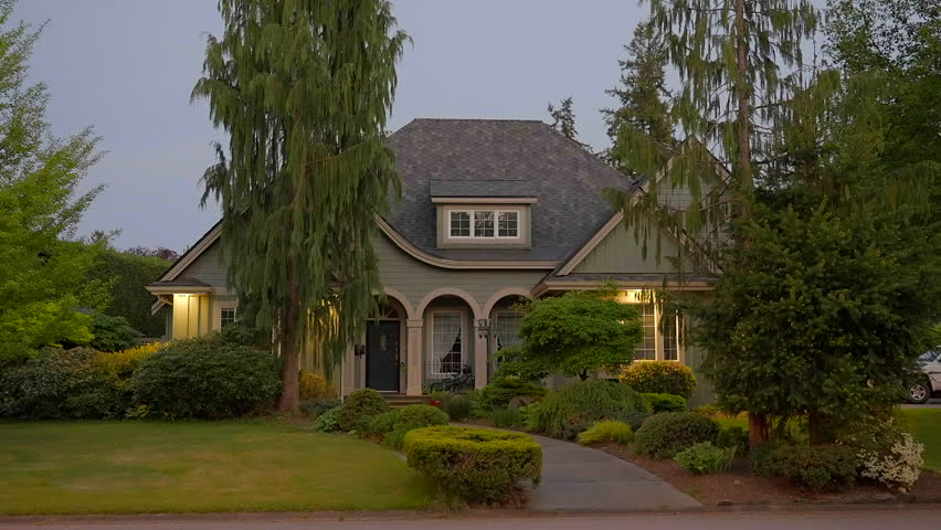 Establishing shot of two story stucco luxury house with garage door, big tree and nice landscape at night in Vancouver, Canada, North America. Night time on Apr 2023. ProRes 422 HQ.