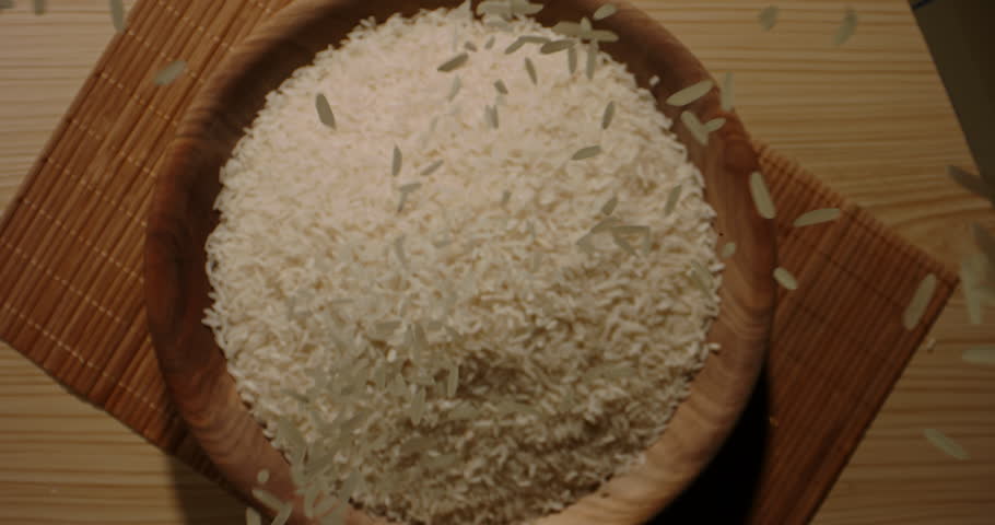 Falling Rice wooden bowl cup. Top view slow motion zoom in. Sushi sashimi, Japanese Chinese Indian Asian Ethnicity cookery. Wooden rice bowl, healthy clean eating. Grain seed vegan uncooked white rice Royalty-Free Stock Footage #1105059593