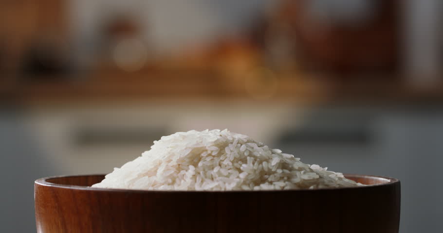 Rice being poured raw wooden bowl side view home kitchen blurred background White rice poured drop down, close up, organic Asian Indian Japanese Chinese food cuisine culture carbohydrate Royalty-Free Stock Footage #1105059701