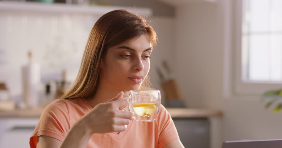 Sleepy female student drink tea, preparing for exam session