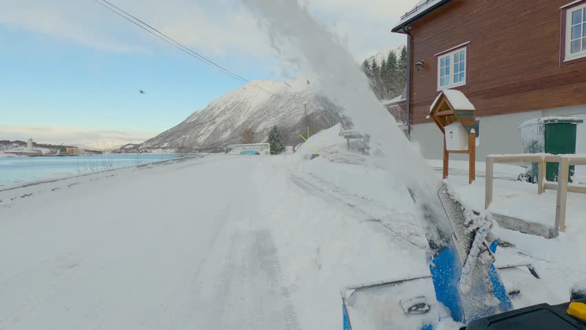 Man struggling removing snow with a snow blower during the winter in Northern Europe