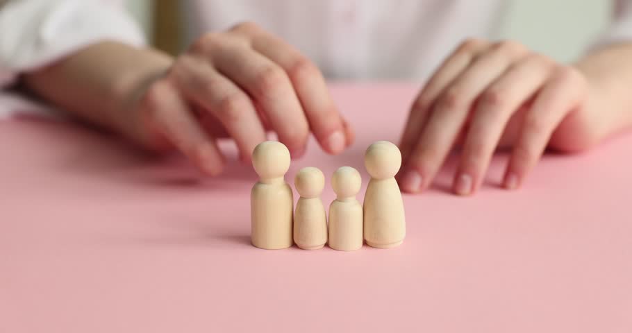 Hands and wooden dolls on a pink background Royalty-Free Stock Footage #1105081657