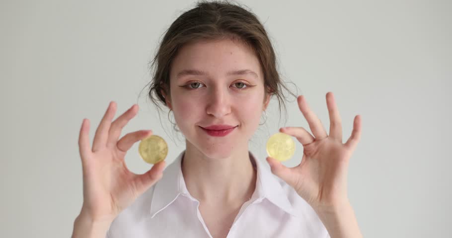 A young woman brings a close-up to the eyes of bitcoins