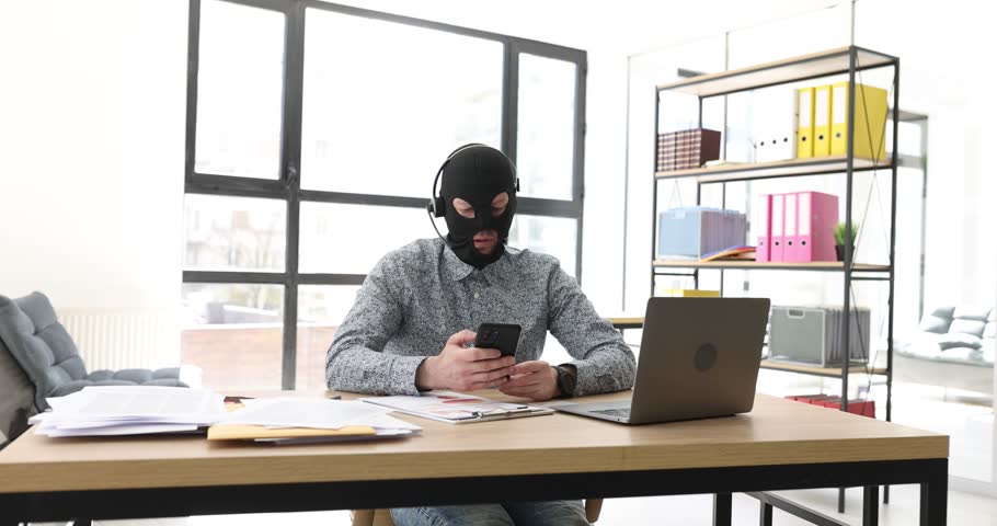 The scammer in the mask is said on the phone, close-up Royalty-Free Stock Footage #1105081695