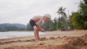 A video of a young boy digging in the sand and running towards the beach water in Thailand