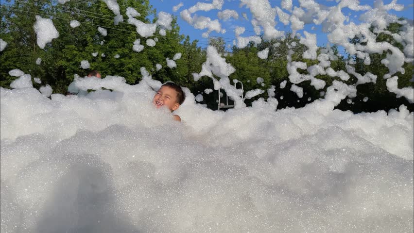Foam party. Children have fun at birthday party outdoor in the yard. Slow motion Royalty-Free Stock Footage #1105085583