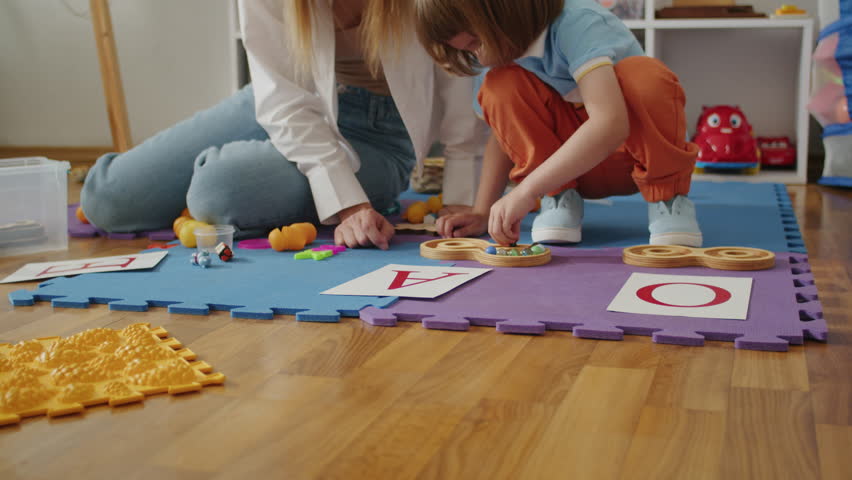 A dedicated tutor and therapist work together to empower a child's speech and language development, fostering a fun and positive learning environment at home Royalty-Free Stock Footage #1105087997