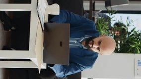 Vertical Video Analyst working with headache in office, feeling unwell and overworked at executive job. Sick businessman not being able to think properly because of painful migraine, project burnout.
