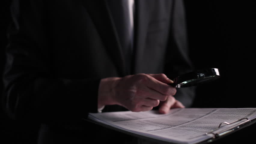 Businessman looking through a magnifying glass to contract Royalty-Free Stock Footage #1105090371